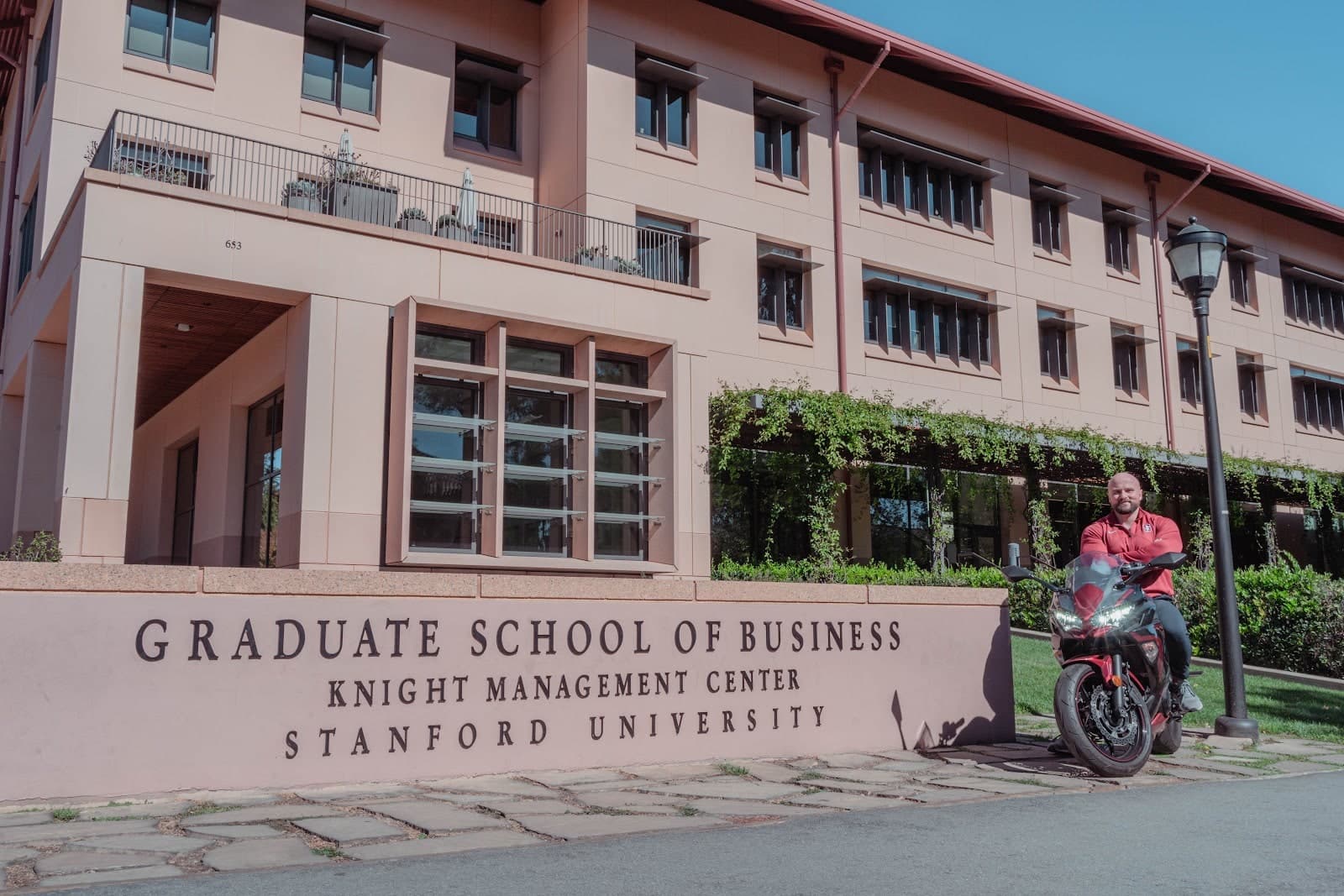 Yegor seated on a red Kawasaki motorcycle by Stanford Graduate School of Business